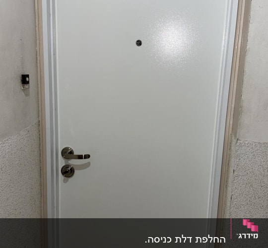 דלת לבנה עם ידית מתכת בקיר לבן